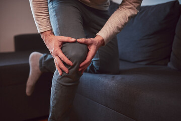 Man with painful knee and leg injury at home.