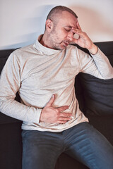 Man with gastritis and abdominal pain at home.
