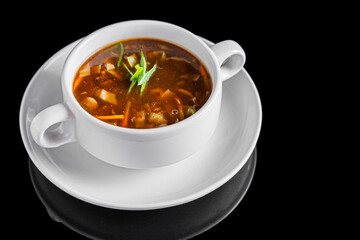 Hot and Sour Soup in White Bowl on Black Background