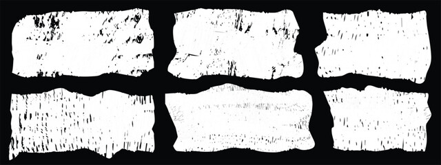 Torn pieces of paper display a variety of textures and shades, arranged in a symmetrical grid. The contrast between the white paper and black background highlights the details.