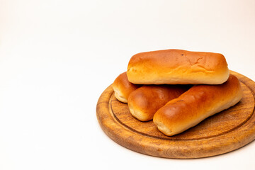 four sausage rolls on a wooden plate