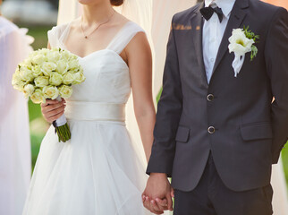 Bride and Groom Holding Hands with Bouquet