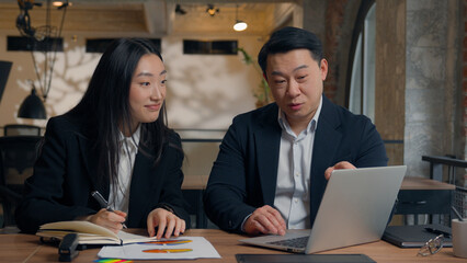 Two Asian business colleagues corporate coworkers partners Korean man businessman work together...