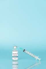 Hepatitis B vaccine vial bottle with syringe on blue background. Hepatitis B vaccine used to...