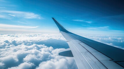 Fototapeta premium A beautiful aerial shot of an airplane wing, with the endless blue sky creating a serene and peaceful view.