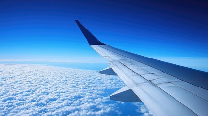 Obraz premium A calm and serene scene of an airplane wing gliding through the deep blue sky with no clouds in sight.