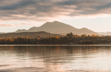 Scenery of sunrise over mountain range and autumn forest on Lake Wanaka