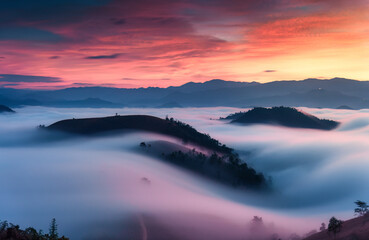 Sea of fog flowing on hill in countryside at sunrise
