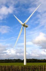 Fototapeta premium Wind turbines on green field blue sky clouds green energy concept renewable energy generator 