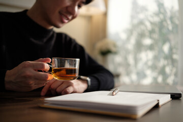 Man enjoying a warm cup of tea while reflecting on his thoughts.