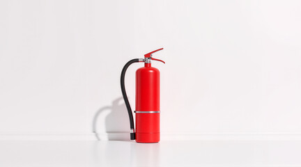 Obraz premium Red Fire Extinguisher on Minimal White Background – Essential Safety Equipment for Insurance Renewal and Hazard Prevention 