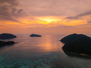 Aerial hyper lapse view of serene sunset over a tropical coastline at Mai Ngam Beach, Surin...