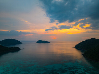 Aerial hyper lapse view of serene sunset over a tropical coastline at Mai Ngam Beach, Surin...