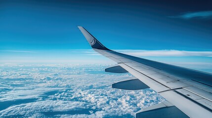 Obraz premium A wing of a commercial airplane high in the sky, with the endless expanse of blue above and below.