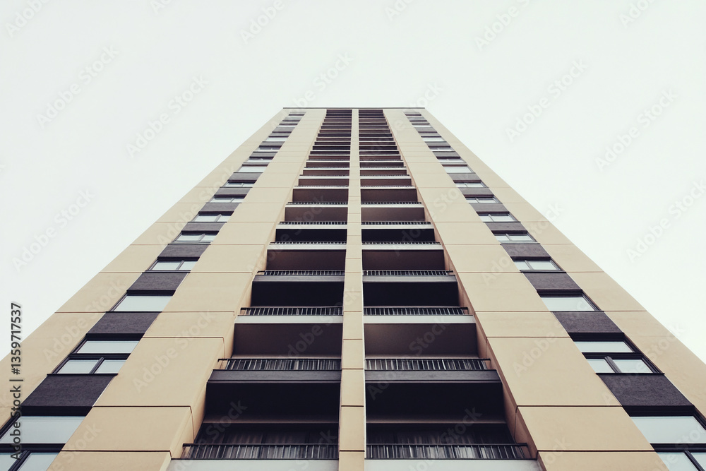 Poster low-angle view of beige high-rise building with dark balconies, showcasing architectural design and 