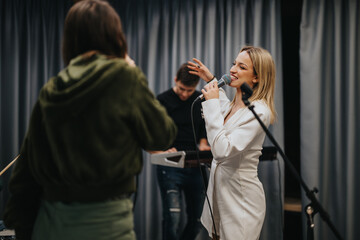 A professional band rehearsing in a music studio with a vocalist and instrumentalists engaged in a...