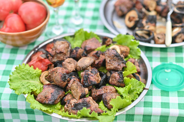 juicy shish kebab served on a large plate with perfectly grilled meat skewers, ready for a delicious family feast or outdoor barbecue party. presentation kebab, authentic middle eastern cuisine.