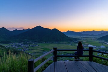 Serene Sunset Over Mountains and Valleys with Silhouette of Woman