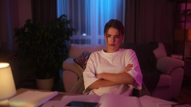 Frustrated young woman working on laptop, hits the desk in anger and leans back in her chair, upset after something goes wrong during remote work in cozy home interior