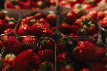 Fresh strawberry at small local urban market. Organic produce on sale at outdoor farmer market. Selling fresh crops and veggies harvest. European urban setting. Close up. Part of the series