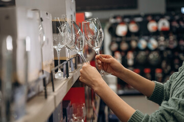 Drink glasses in hands. Close up view of woman that is in the hardware store