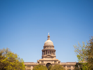 Austin Texas State Capitol Building with American flag and Texas flag