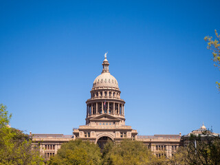 Austin Texas State Capitol Building with American flag and Texas flag