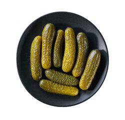 pickled cucumbers on a black plate isolated on a white background, top view.