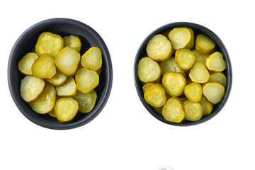 chopped pickled cucumbers in a black bowl isolated on a white background, top view.