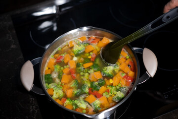 Vegetable soup cooking on induction stove