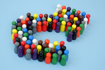 Many different colorful wooden people figures shaped as arrow on blue background. 