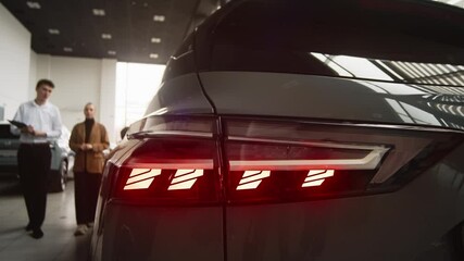 A car sales manager shows a vehicle to a customer in a luxurious dealership. Concept a premium car-buying experience that combines expert guidance with high-end service in an elegant setting.