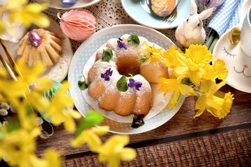 Top view of traditional Easter ring cake with fresh flower decoration on festive table
