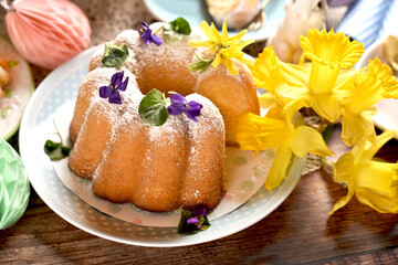 Closeup of traditional Easter ring cake with fresh flower decoration on festive table