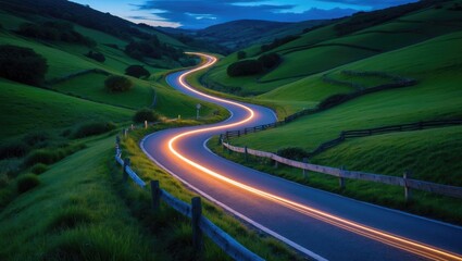 Winding curvy rural road with light trails from headlights leading through the countryside.