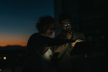 Business colleagues working late on a project under dim lighting conditions © qunica.com