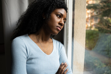 A black woman very sad thinking in front of window