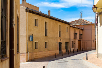 Calle tranquila del centro histórico de Segovia, España, con casas de estilo tradicional y detalles ornamentales.