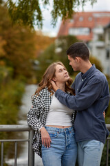 Fototapeta premium Young Cute Female Hugs Boyfriend. In Autumn Outdoor. Lovers Walking in Park. Attractive Funny Couple. Lovestory in Forest. Man and Woman. Cute Lovers in the Park. Family Concept. Happy Couple.