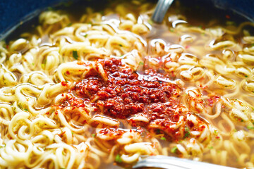 Instant noodles fork and spoon in a bowl. Spicy noodle soup. Asian food style.