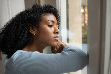A black woman very sad thinking in front of window