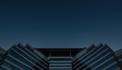 Modern building with geometric design under a dark night sky, low angle shot.