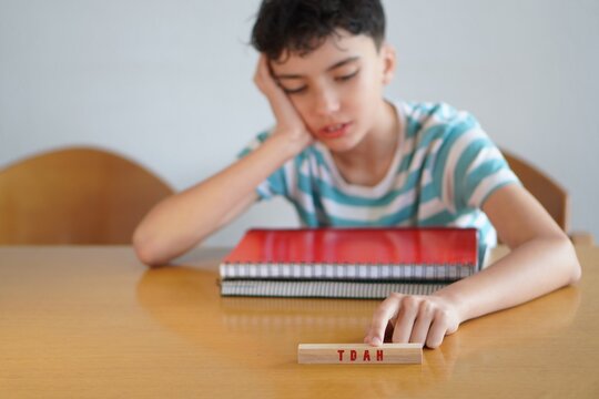 tdah. ni&ntilde;o adolescente con cuadernos y libretas se&ntilde;alando esta problematica