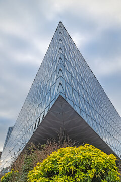 Geneva, Switzerland - January 16. 2025: The glass and steel building front of Japan Tobacco International (JTI) headquarter looking over the Swiss railway station Geneva-Sechron.