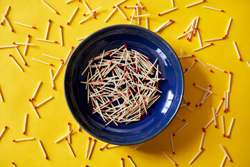Matches in dark blue bowl over yellow background