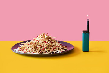 Pile of wooden matches on plate with lighter over pink yellow background.