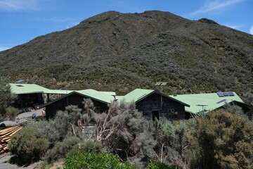 Landscape with buildings of mountain shelter Saddle Hut on trail to Mount Meru, Arusha National...