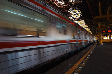 the commuter city train moves forward leaving the station,  The train has multiple passenger car.