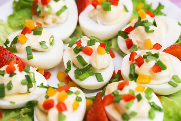 Hard boiled eggs with chives and paprika. Eggs cut in half with mayo background. Simple and delicious dish for breakfast. Lunch snack idea. Perfect for a nutritious meal with vibrant seasoning.