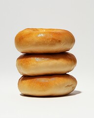 Obraz premium Stack of Three Plain Bagels on White Background in Simple Close-up Studio Shot